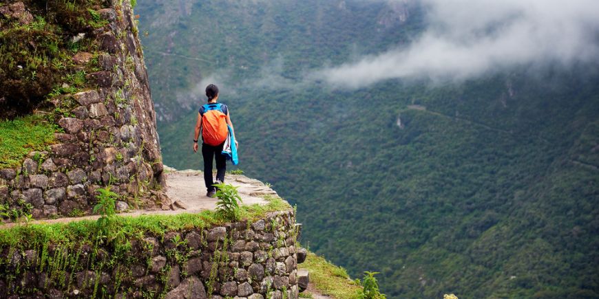 Woman walking on edge of cliff