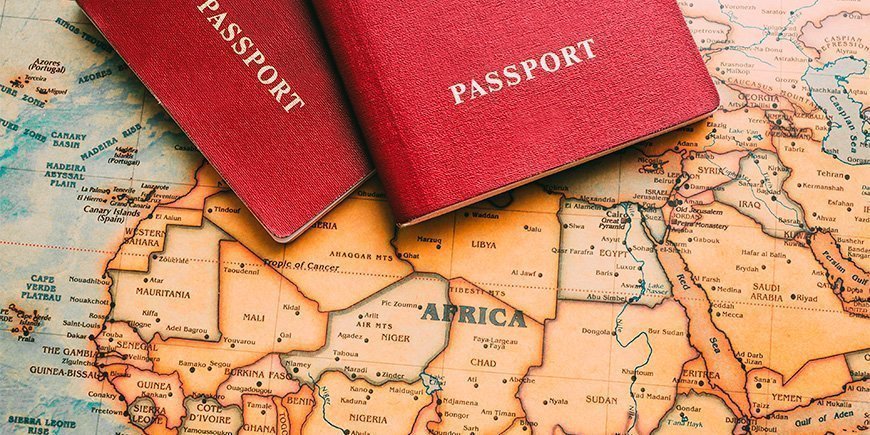 Two passports are on maps of Africa