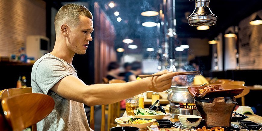 Man eats with chopsticks at restaurant in Vietnam