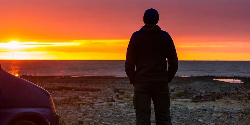 Man enjoying sunset by the water in New Zealand
