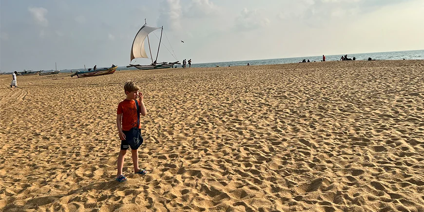 Boy standing on Negombo Beach in Sri Lanka