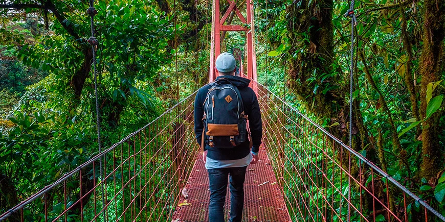 Man walking alone on a suspension bridge in Monteverde Cloud Forest in Costa Rica