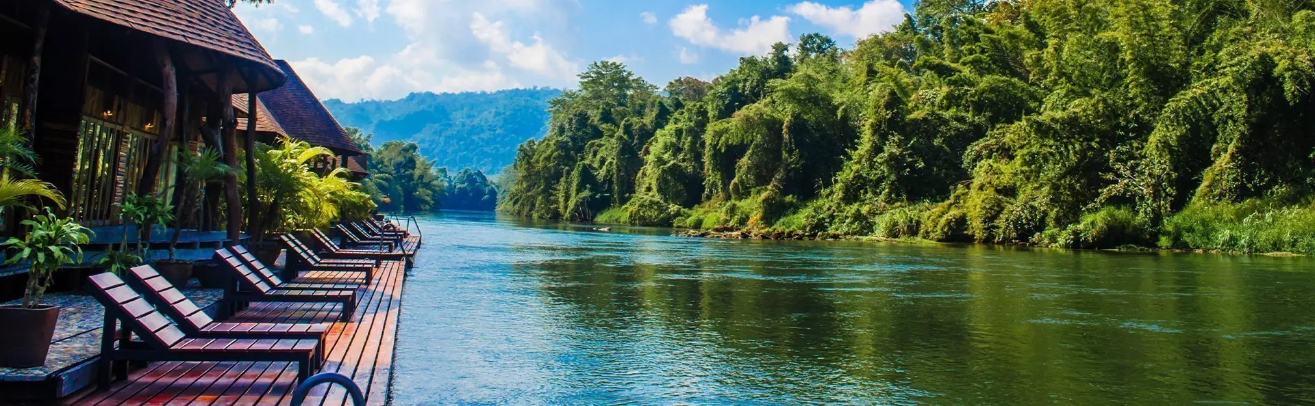 Lounge chairs surrounded by lush greenery on the River Kwai.