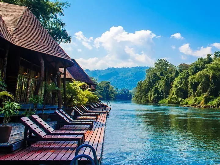 Lounge chairs surrounded by lush greenery on the River Kwai.