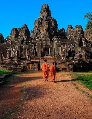 2 monks in front of the Bayon Temple at Angkor in Cambodia